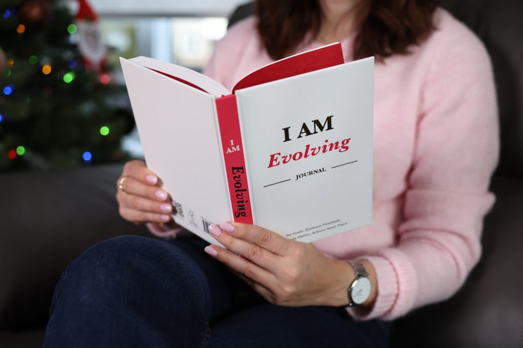 Woman reading a book titled "i am evolving"