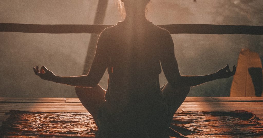 Woman sitting peacefully outdoors taking a deep breath during a reset moment